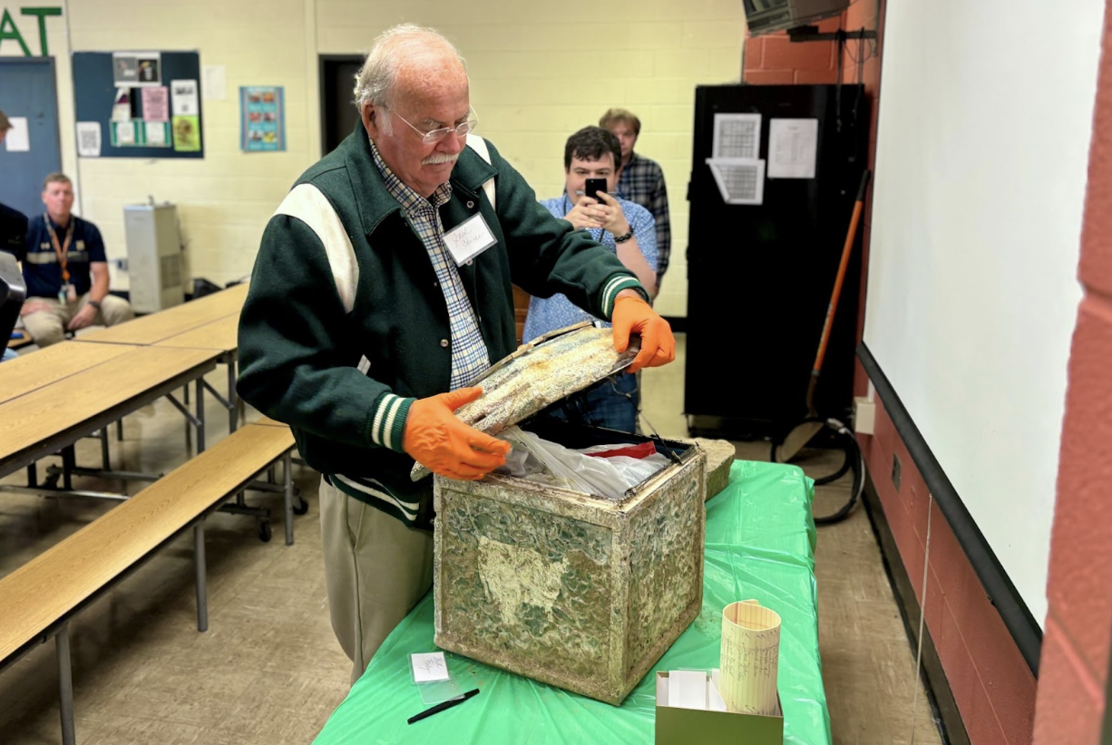 Jack Chiras, former history teacher, opens the time capsule during the ceremony
